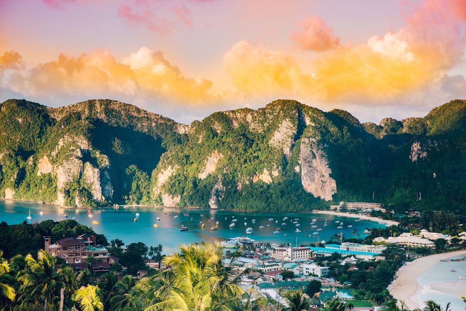 Turquoise Thai bay with limestone cliffs and longtail boats