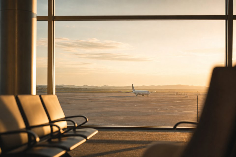 Quiet airport window light over an empty tarmac